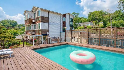 een huis met een zwembad en een gebouw bij Ganghwa Ara Pension in Incheon