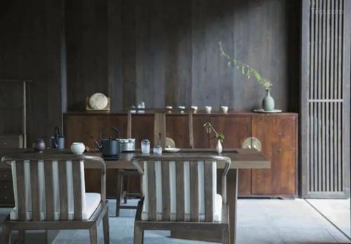 een eetkamer met een tafel en twee stoelen bij Tsingpu Tulou Retreat 青普文化行馆 南靖土楼店 in Nanjing