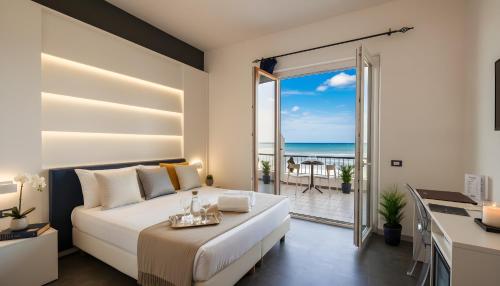 een slaapkamer met een bed en uitzicht op de oceaan bij Hotel La Battigia in Alcamo Marina