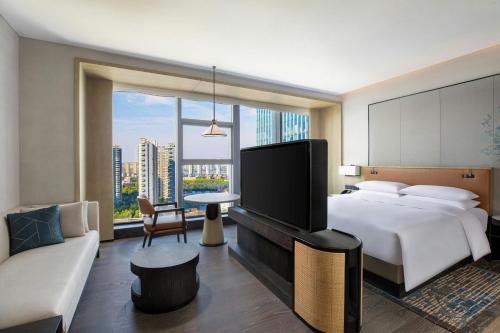 een hotelkamer met een bed en een groot raam bij Courtyard by Marriott Luoyang in Luoyang