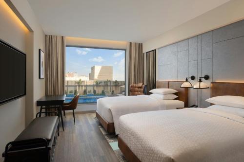 ein Hotelzimmer mit zwei Betten und einem Fenster in der Unterkunft Four Points by Sheraton Amritsar, Mall Road in Amritsar