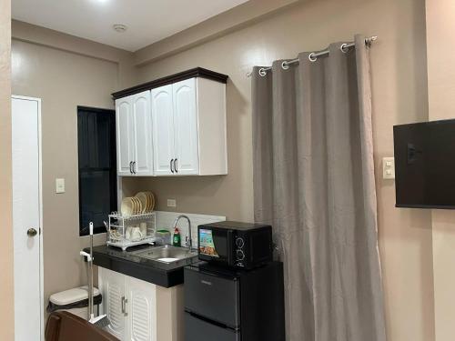 a small kitchen with a sink and a microwave at Daniel's Comfort Studio in Hipusñgo