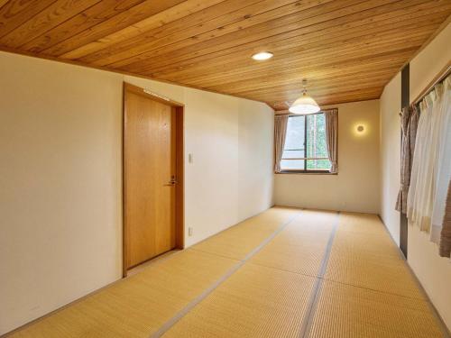 een lege kamer met een houten plafond en een deur bij Runesu Karuizawa - Vacation STAY 78428v in Tsumagoi