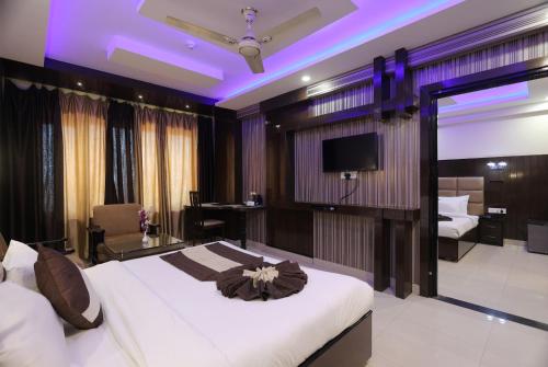 een hotelkamer met een bed en een tv bij Hotel Crystal Ganga Heights 5 Min from Har Ki Pauri in Haridwār