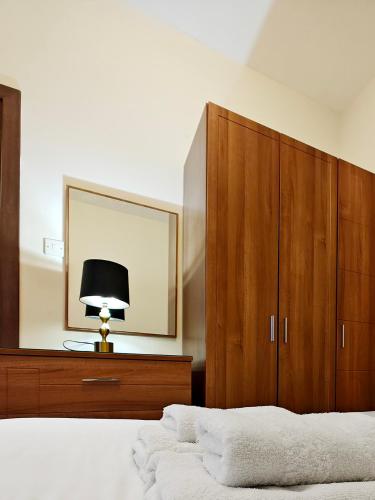 a bedroom with a bed with a mirror and a lamp at Speranza in Il-Gżira