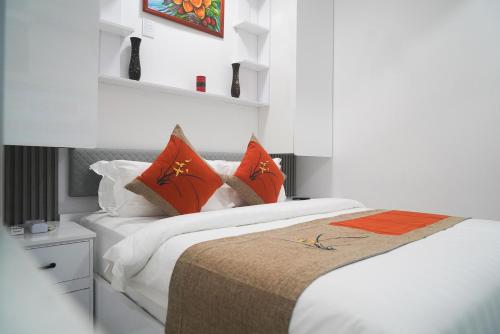 2 bedden met oranje kussens in een slaapkamer bij LemonRock Comfort in Male City