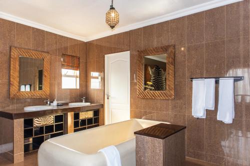 een badkamer met een bad en een wastafel bij 305 Guest House in Amanzimtoti