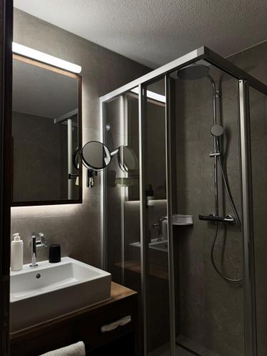 een badkamer met een wastafel en een douche bij Hotel Central in Ischgl