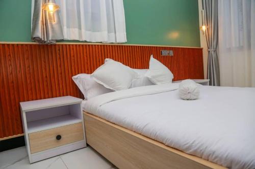een slaapkamer met twee bedden en een nachtkastje bij Sunset Statehouse View Residence in Entebbe