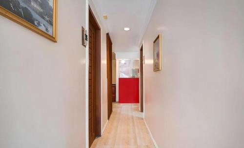 un corridoio con pareti bianche, pavimenti in parquet e dipinti di Zia Suites a Bugo