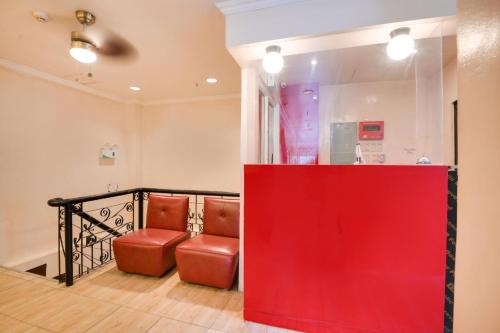 una stanza con due sedie rosse e un muro rosso di Zia Suites a Bugo