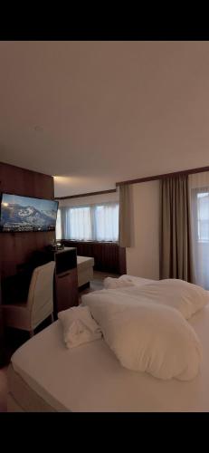 ein Hotelzimmer mit zwei Betten und einem Schreibtisch in der Unterkunft Hotel Central in Ischgl