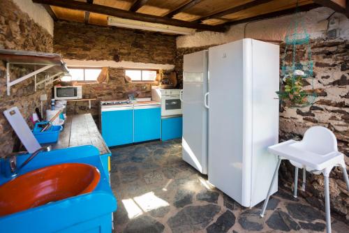 una cucina con mobili blu e un frigorifero bianco di Monte Pedras Negras a São Luis