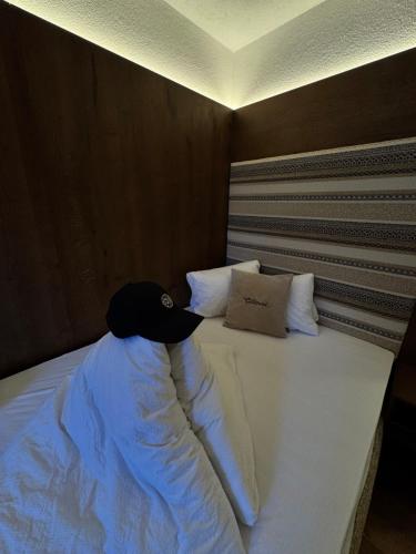 ein Bett mit einem schwarzen Hut darauf in der Unterkunft Hotel Central in Ischgl