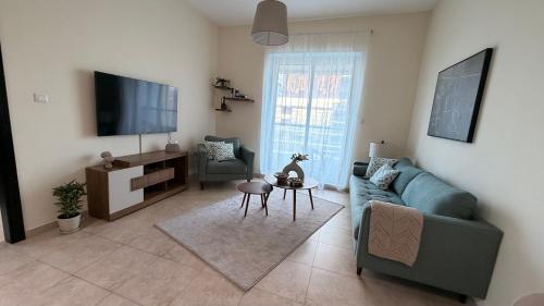 a living room with a couch and a tv at Dar Al Noor Apartment in Dubai