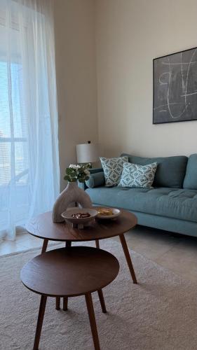 a living room with a blue couch and a table at Dar Al Noor Apartment in Dubai