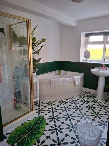 a bathroom with a tub and a sink at Newby Cross in Carlisle