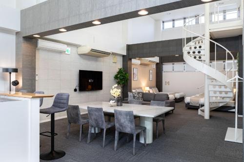 a room with a table and chairs and a staircase at Bijou Suites AI PREMIUM in Osaka