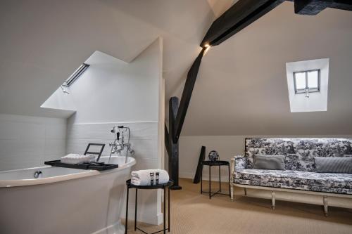 un soggiorno con divano e lavandino di Maleyssie Les Suites a Chartres