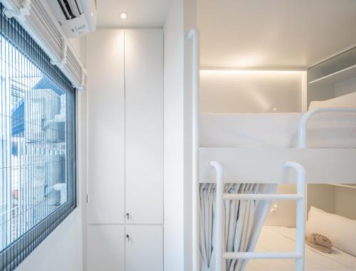 a room with white walls and a window at Bedd Hostel in Bangkok