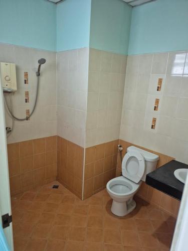 ein Badezimmer mit Toilette und Waschbecken in der Unterkunft Chonnatee Residence in Chum Phae