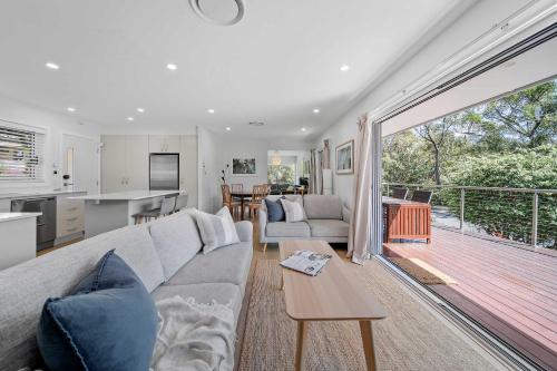 a living room with a couch and a table at Elements of Hyams - perfect Hyams Beach getaway in Hyams Beach