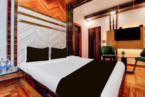 een slaapkamer met een groot bed en een bureau bij Hotel O Siris Luxury Cottage Amatra Dunsvirk Court in Mussoorie