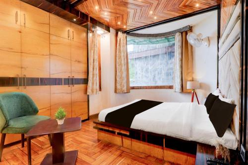 een slaapkamer met een bed en een stoel bij Hotel O Siris Luxury Cottage Amatra Dunsvirk Court in Mussoorie