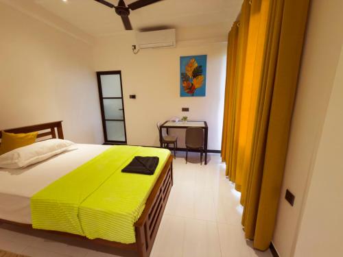 una camera da letto con un grande letto con una coperta gialla di Lagoonlike Hiriketiya a Dikwella