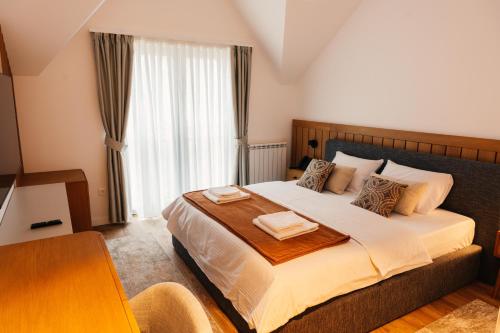 een slaapkamer met een groot bed met twee handdoeken erop bij Hotel Nordik in Motički Gaj