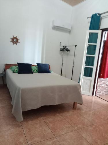 a bedroom with a large bed with blue pillows at Appartement Le Papangue in Saint-Paul