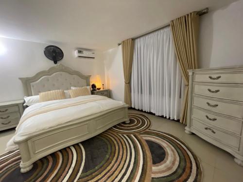a bedroom with a large bed and a rug at Masaki Comfort III Dar es Salaam Tanzania in Dar es Salaam