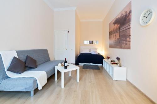 sala de estar con sofá azul y cama en Lux Apartments - Seliverstov Pereulok, en Moscú