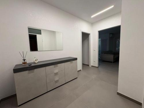 een witte keuken met een wastafel en een spiegel bij B&B Relais in Francavilla al Mare