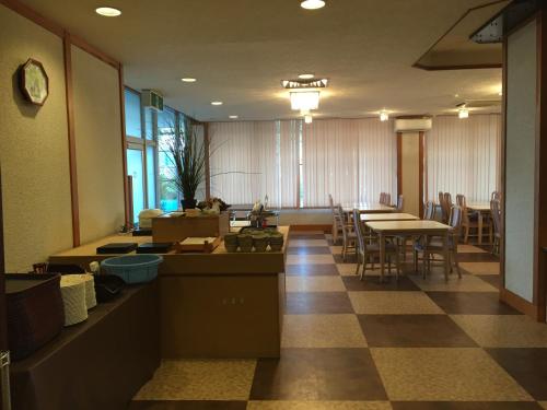 a waiting room with tables and chairs in a building at Hotel Kadoman in Aso