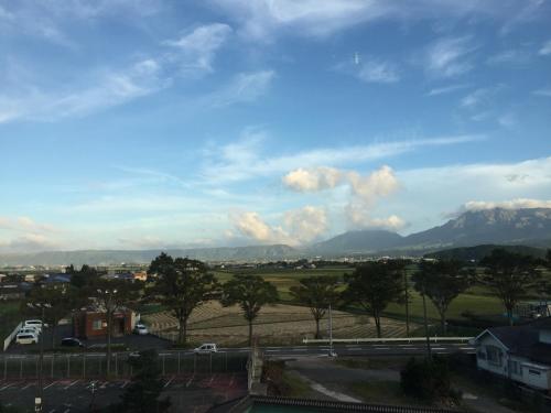 a view of a city with mountains in the background at Hotel Kadoman in Aso