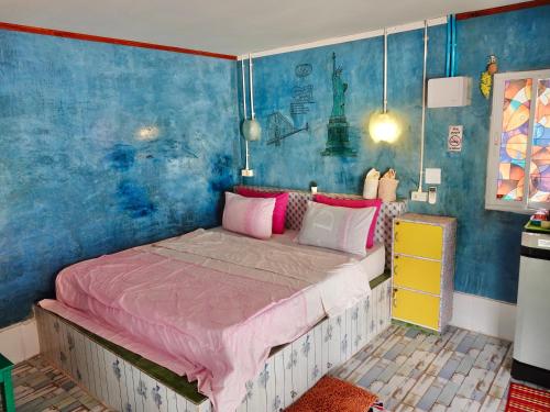 a bedroom with a large bed with pink sheets at Banpu Beach Ao Lung Dam,Koh Samet in Ao Phutsa