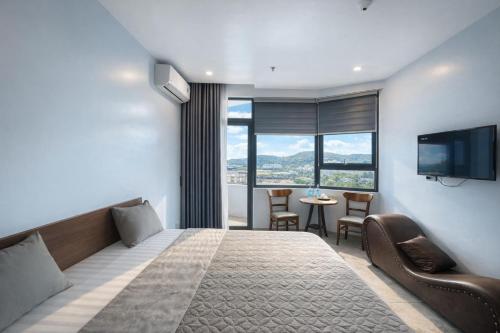 een hotelkamer met een bed en een televisie en een tafel bij Như Ý Hotel Hà Giang in Ha Giang