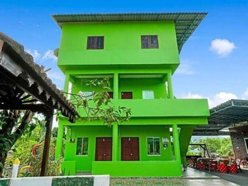 ein grünes Haus mit einem Dach in der Unterkunft OYO 90462 Padang Besar Green Inn in Padang Besar