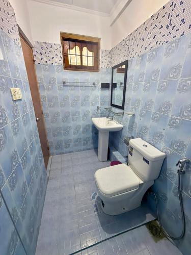 a blue and white bathroom with a toilet and a sink at Lagoonlike Hiriketiya in Dickwella