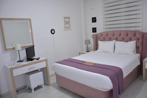 a bedroom with a bed and a desk with a mirror at Bilge Suite Hotel in Corum