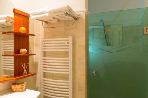 La salle de bains est pourvue d'une douche avec une porte en verre. dans l'établissement Karos Gold 813 Wellness Apartman, à Zalakaros