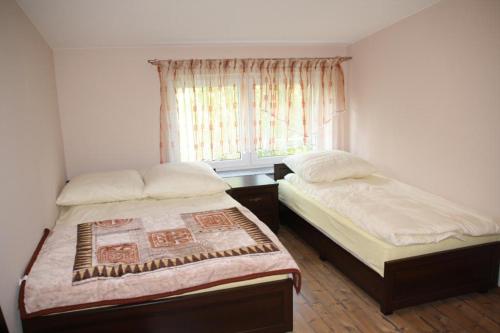 a bedroom with two beds and a window at Hotel For You in Pabianice