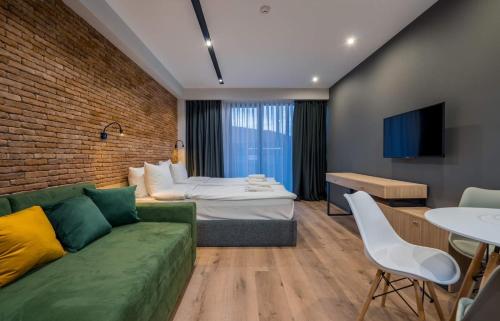 een woonkamer met een bank en een bed in een kamer bij New Gudauri Atrium Apartments in Goedaoeri