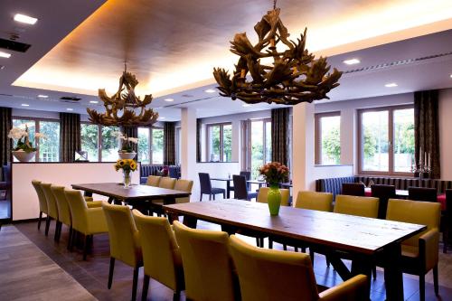 ein Restaurant mit Holztischen und gelben Stühlen in der Unterkunft Hotel Restaurant Anna in Schnelldorf
