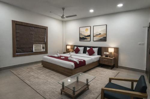 ein Schlafzimmer mit einem Bett und einem Tisch darin in der Unterkunft Hotel Opulence Kalinga in Mancheshwar