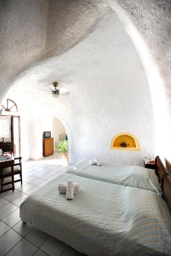 una camera da letto con un letto su cui sono appoggiati due asciugamani di Kavalari Hotel - Adults Only a Firà