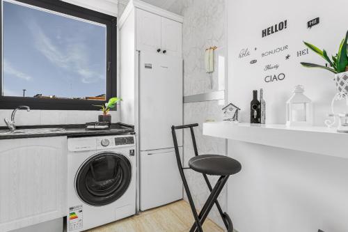 eine weiße Küche mit Waschmaschine und Theke in der Unterkunft Mar Y Sol in Caleta de Fuste