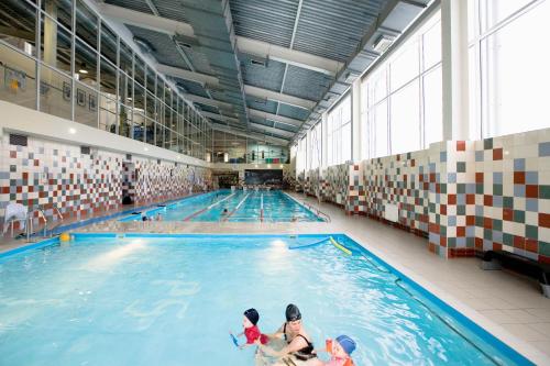 a group of people swimming in a swimming pool at Petro Sport Hotel in Saint Petersburg