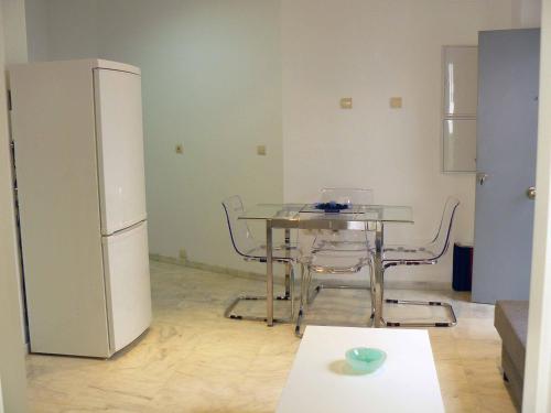セビリアにあるAlfaqueque Apartmentのキッチン(テーブル、白い冷蔵庫付)